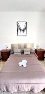 - une chambre dotée d'un grand lit avec un animal blanc dans l'établissement Casa típica Andaluza El Lucero, à Rute