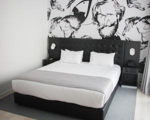 Schlafzimmer mit einem Bett mit einer schwarz-weißen Wand in der Unterkunft Hotel Verdi in Sliema