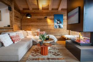 a living room with a couch and a fireplace at Chalet Fernand - OVO Network in La Clusaz