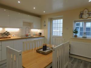 a kitchen with a wooden table and a dining room at St Christophers Cottage, Sheringham - Keys Holiday Cottages in Sheringham