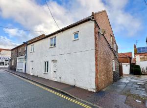 a white building on the side of a street at St Christophers Cottage, Sheringham - Keys Holiday Cottages in Sheringham