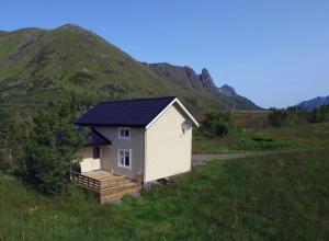 una pequeña casa con techo solar en una colina en Charming house by the sea, Lofoten!, en Laupstad