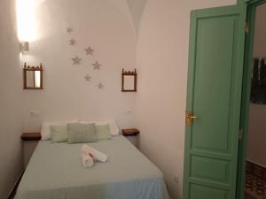 sypialnia z łóżkiem z zielonymi drzwiami w obiekcie Casa de las Bóvedas w mieście Rosal de la Frontera