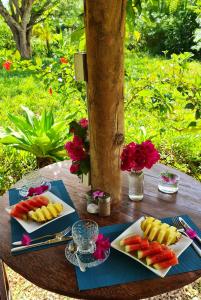 Frangipani House Nungwi Zanzibar في نونغوي: طاولة خشبية عليها صحون طعام