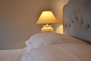 ルッカにあるホテル アルベルゴ ヴィラ マルタのベッド(ランプ付)