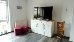 ein Wohnzimmer mit einem großen Flachbild-TV in der Unterkunft Haus Maisonette am Harz in Niedersachswerfen