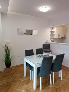 Una mesa y sillas blancas en una habitación. en Korzo Apartment, Subotica, en Subotica