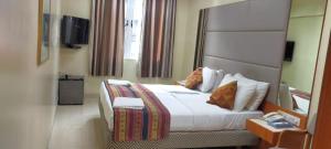 sypialnia z dużym łóżkiem z białą pościelą i poduszkami w obiekcie Empire Hotel - Grant Road w Bombaju