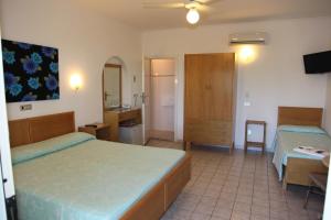 una camera d'albergo con due letti e un bagno di Hotel Paradiso a Portoferraio