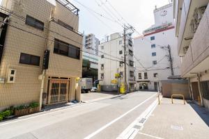 een lege straat in een stad met gebouwen bij 大阪道顿堀 铁甲猫の家 in Osaka