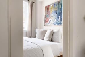 Schlafzimmer mit einem Bett mit weißer Bettwäsche und einem Spiegel in der Unterkunft Das Fachwerkhäuschen am Kornmarkt - herzlich & charmant in Quedlinburg