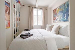 Schlafzimmer mit einem großen weißen Bett und einem Fenster in der Unterkunft Das Fachwerkhäuschen am Kornmarkt - herzlich & charmant in Quedlinburg