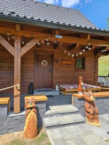 una cabina di legno con due statue di orso di fronte ad essa di Chata na Lazoch - Raj v prírode a Lazy pod Makytou