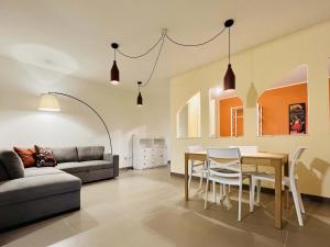 a living room with a couch and a table and chairs at Sebeto Apartment in Naples