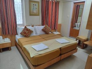 a bedroom with a large bed with two pillows on it at Empire Hotel - Grant Road in Mumbai