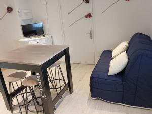 uma sala de estar com um sofá azul e uma mesa em Chez Rémi em Meximieux