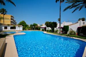 a swimming pool in a resort with palm trees at Las Meninas in Denia