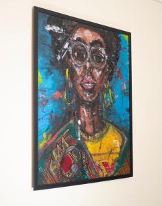 a painting of a woman with glasses on a wall at ChallawaRiver Homes in Calabar