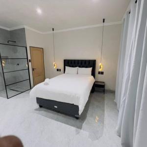 a bedroom with a large white bed and a mirror at Cosy 2 bed house w power backup in Sandton