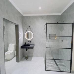 a bathroom with a shower and a sink and a toilet at Cosy 2 bed house w power backup in Sandton