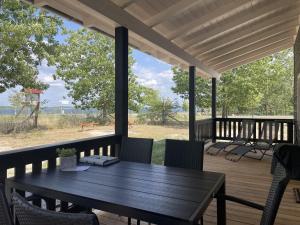 a wooden deck with a table and chairs on it at Safarilodge am Bärwalder See in Klein Uhyst