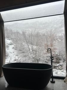 a bath tub sitting in front of a window at North Alpine Villas in Bogë