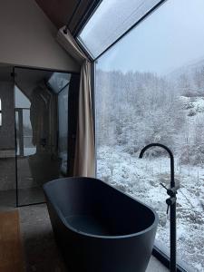 eine Badewanne vor einem Fenster in der Unterkunft North Alpine Villas in Bogë