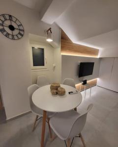 een witte eetkamer met een witte tafel en stoelen bij Athens Cosy Semi-Basement Apartment in Athene