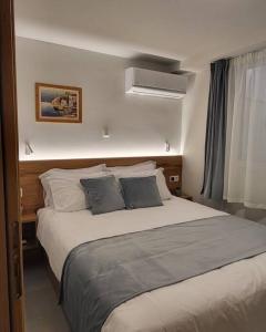 een slaapkamer met een groot bed met 2 kussens bij Athens Cosy Semi-Basement Apartment in Athene