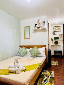 a bedroom with a bed with a hat on it at Amancio's Balai - Near the Airport, City Center! in Puerto Princesa City