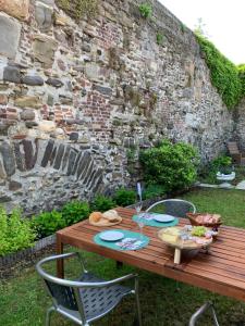 uma mesa de madeira com pratos de comida ao lado de uma parede de pedra em De Stadswal em Maastricht
