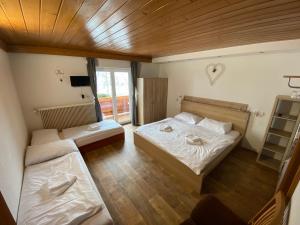 um quarto com duas camas e uma tv nele em Pension Tyrol em Maria Alm am Steinernen Meer