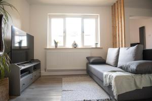 a living room with a couch and a window at Dorset Stylish Apartment in Poole