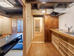 uma cozinha com armários de madeira e uma bancada em Sumire-an Machiya House em Quioto