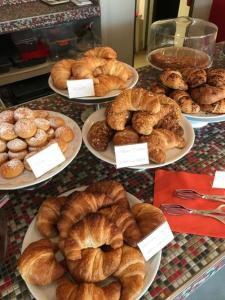una exposición de diferentes tipos de panes y pastas en platos en Hotel l'Etrusco - San Vincenzo, en San Vincenzo