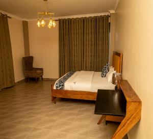 a bedroom with a bed and a table and a chair at Star View Hotel Restaurant and Bar in Kampala