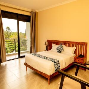 a bedroom with a bed and a balcony at Star View Hotel Restaurant and Bar in Kampala