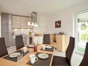 cocina y comedor con mesa y sillas en Auszeit Ferienhaus, en Gross Schwansee