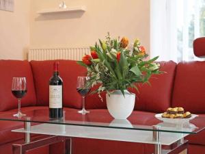 una botella de vino y un jarrón de flores sobre una mesa en Am Dünenweg Uns Hüsung Whg 3, en Boltenhagen