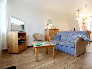 a living room with a blue couch and a table at Altes Zollhaus, Fewo- Nr 4 in Barendorf