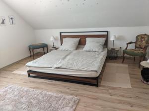 a bedroom with a bed and two chairs at FeWo Wiesenallee OG in Geeste