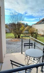 a table and chairs on a balcony with a view of a river at Gîte "Fleur de Jeannette" in Torpes
