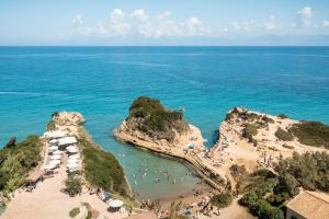 an aerial view of a beach with people in the water at Akron Seascape Resort, a member of Brown Hotels in Sidari