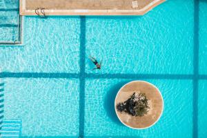 an overhead view of a swimming pool with a person in the water at Akron Seascape Resort, a member of Brown Hotels in Sidari