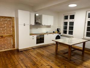 a kitchen with white cabinets and a table in it at 170m2 apartment in Historical building in Gutenzell-Hürbel