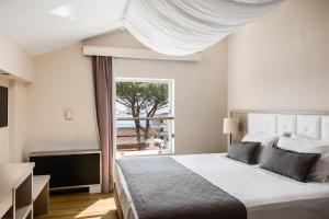 a bedroom with a large bed and a window at Akron Seascape Resort, a member of Brown Hotels in Sidari