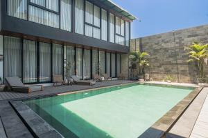 a swimming pool in front of a building at Forseti Athena in Seminyak