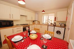 a kitchen with a table with a red polka dot table cloth at 2 Old Dairy Court in Sheringham