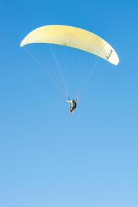 una persona montando un paracaídas en un cielo azul en Maison Isabelle, en Plouézec