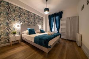 um quarto com uma cama com um cobertor azul em Élégant T3 Le Petit Palais Avignon em Avignon